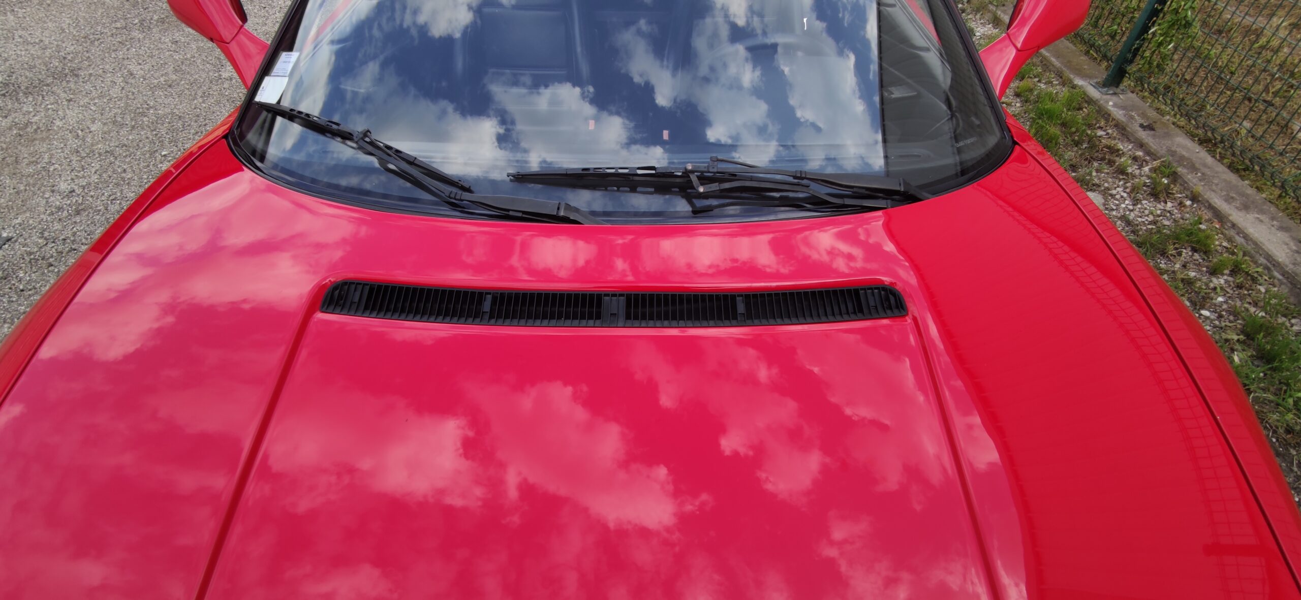 Photographie d'une voiture avec un effet miroir après une prestation de polissage polissage automobile à Grenoble chez Cars in Style à Grenoble sur une Ferrari